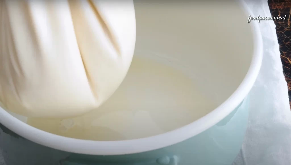 squeezing the soy milk with a cheesecloth