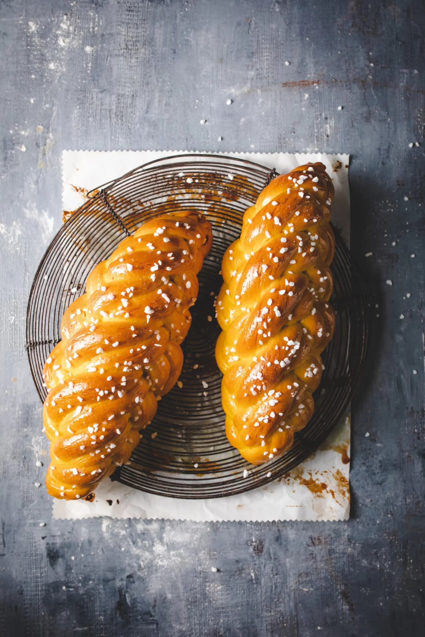 two vegan pumpkin challah loaves on a wire rack