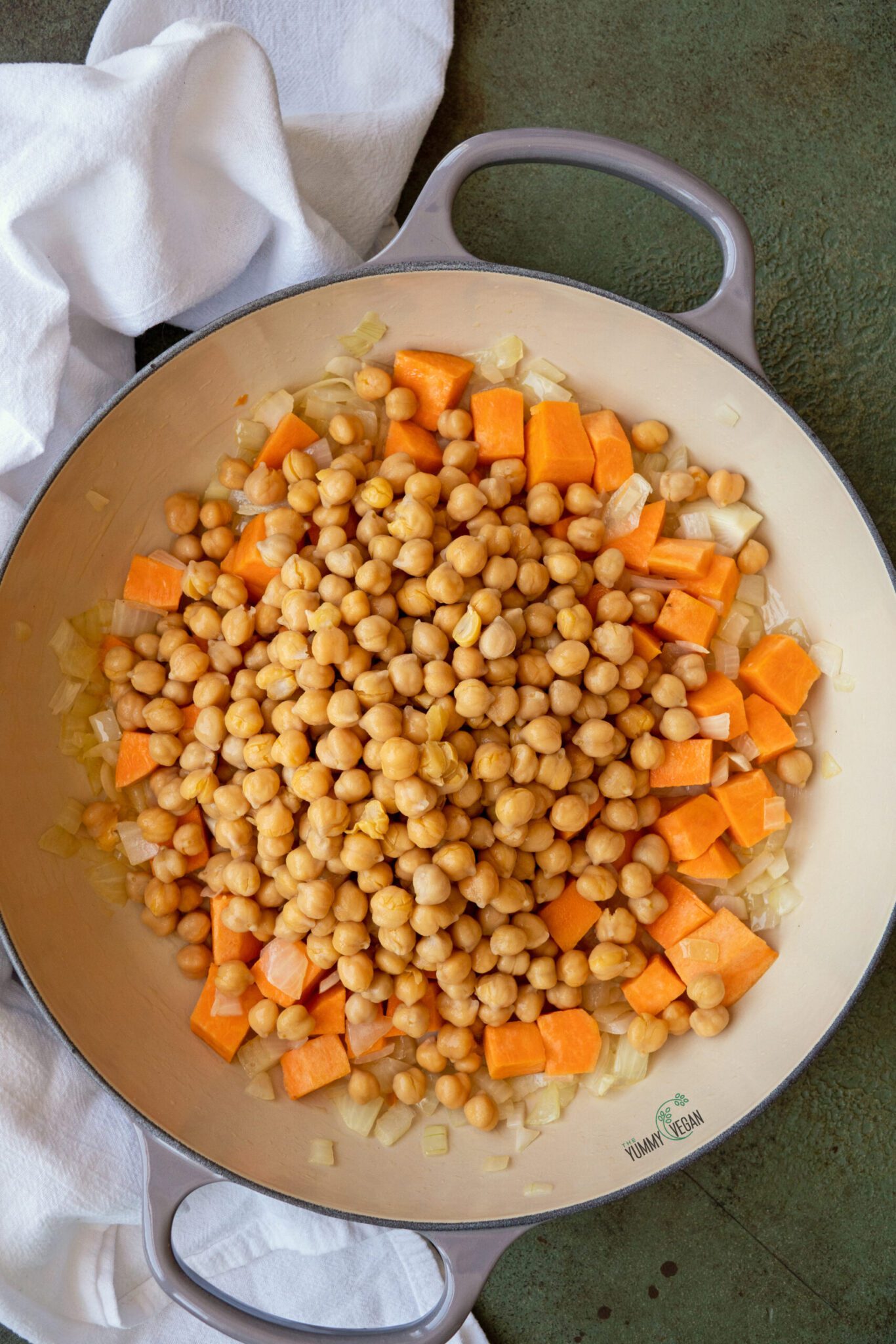 onions, chickpeas, and sweet potatoes in a pot