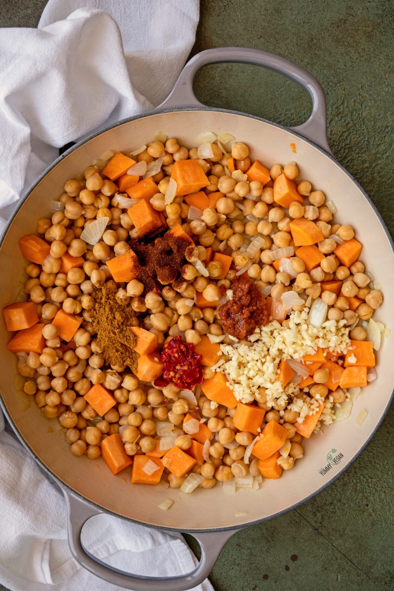 onions, chickpeas, spices, and sweet potatoes in a pot