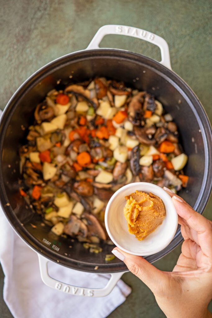 Mushroom Barley Soup - miso being added to the pot