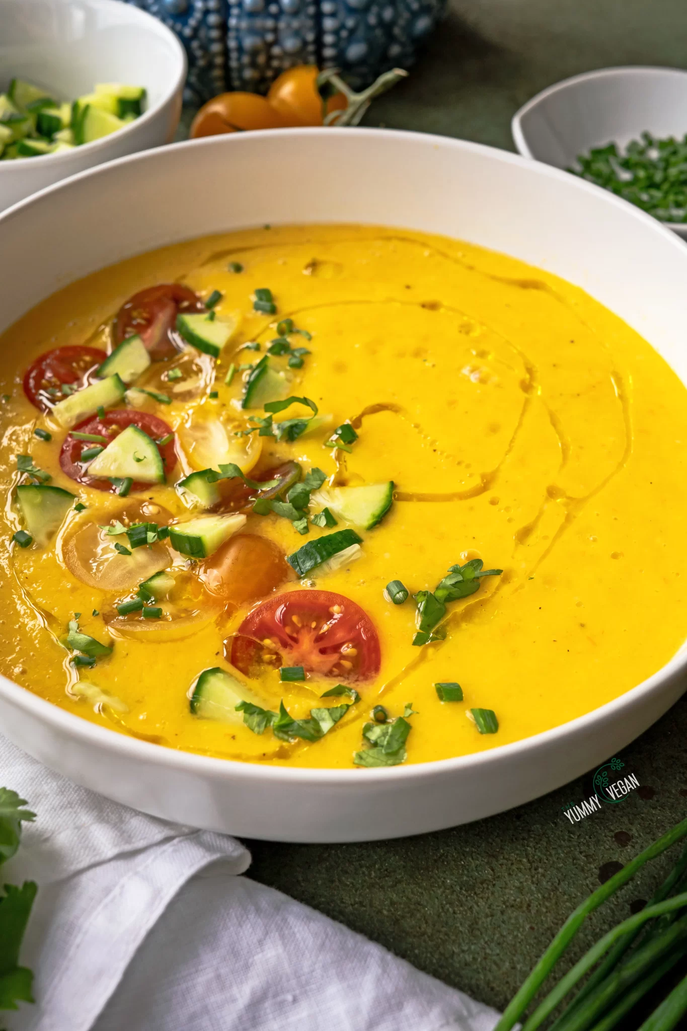 yellow gazpacho garnished with beautiful toppings in bowl