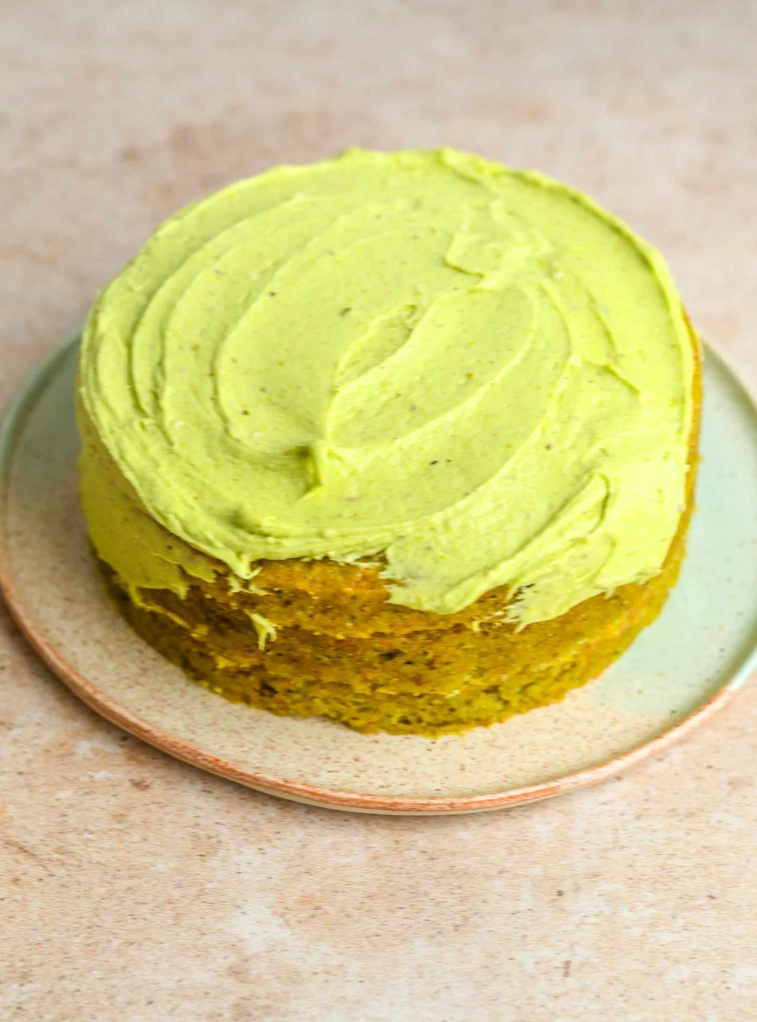 buttercream frosting being added to the whole cake