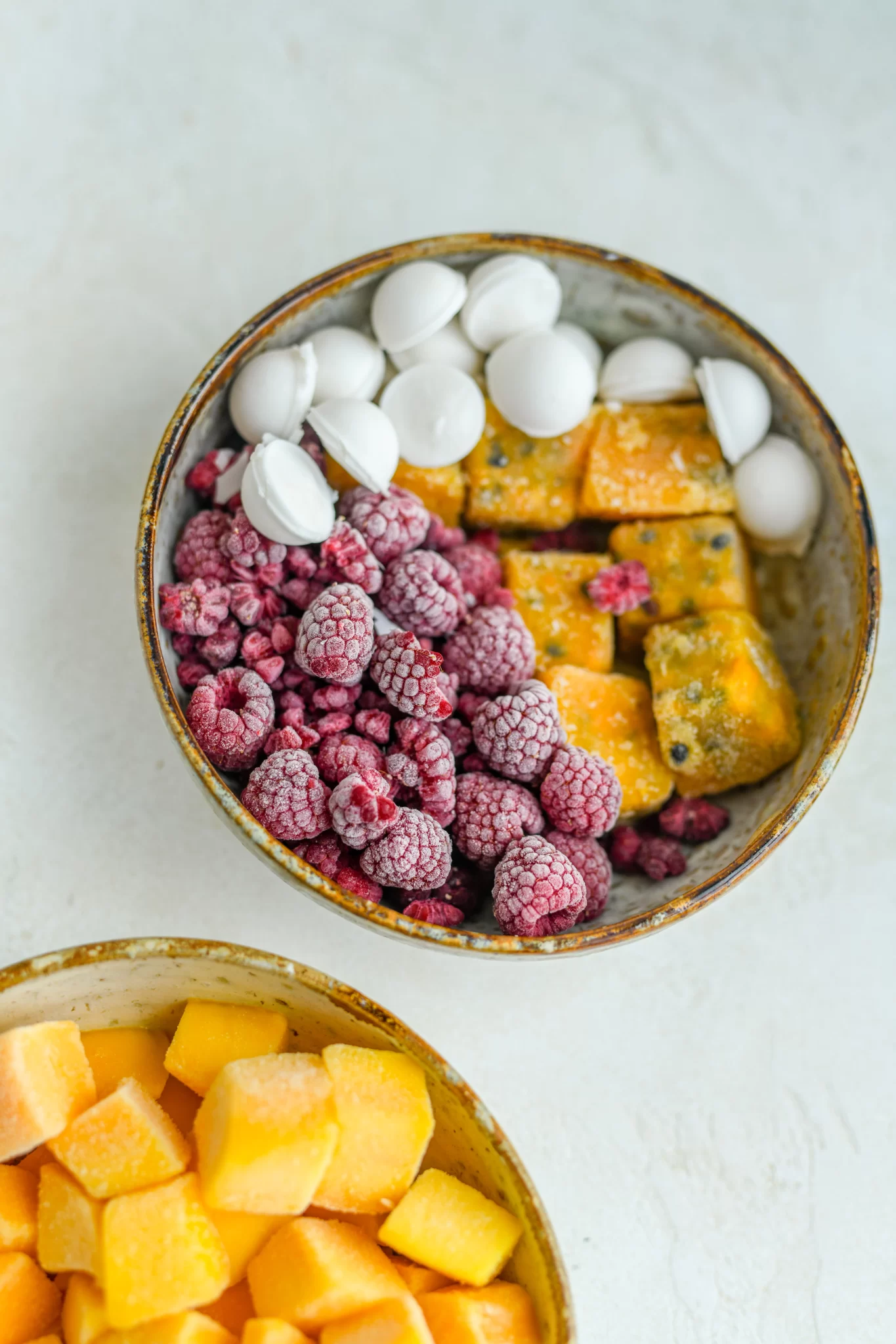frozen coconut, frozen passionfruit, and frozen raspberries in a bowl